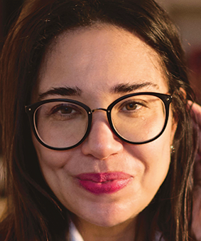 Close-up photo of a woman's face with dark hair and glasses