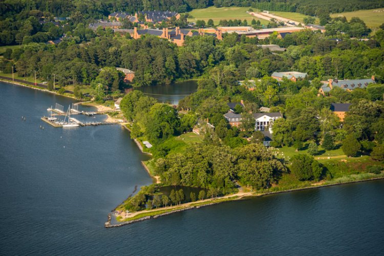 An aerial shot displaying a small peninsula extending into a large body of water.