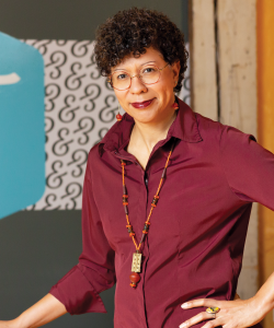 Arleta Little of the Loft Literary Center Arleta Little, a Black woman with close-cropped curls and thin-framed glasses, smiles with one hand on her hip. She wears a maroon collared shirt and beaded necklace.