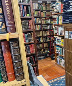 Photographs of a room with shelved books and a hand cart 