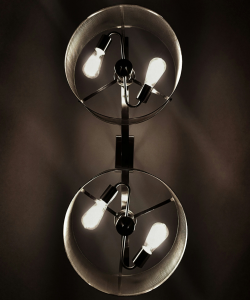 A dark and moody photograph of two identical lamps, each with two identical bulbs