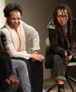 Two Black poets lean in to a discussion panel at the Guggenheim 
