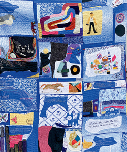 A person holds up a large quilt with blue fabric and small pops of color. Blue Quilt