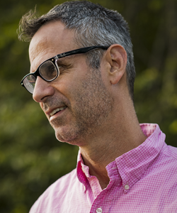 A man in a pink shirt and glasses. Steve Almond