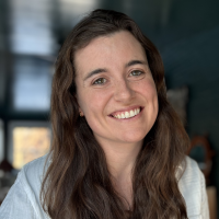 Headshot of Emma Dries Headshot of Emma Dries, smiling in front of a window