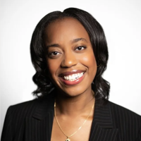 Headshot of Sian-Ashleigh Edwards, smiling and wearing business attire in front of white background